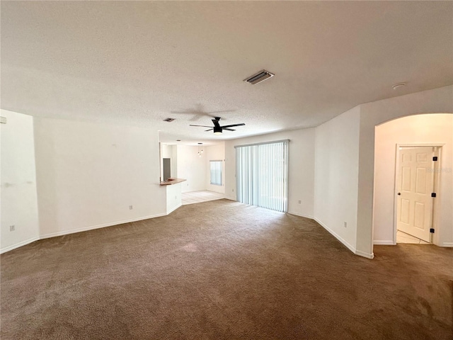 15 Ruth Dr, Palm Coast, FL 32164 - unfurnished living room with carpet flooring, ceiling fan, arched walkways, baseboards, and a textured ceiling