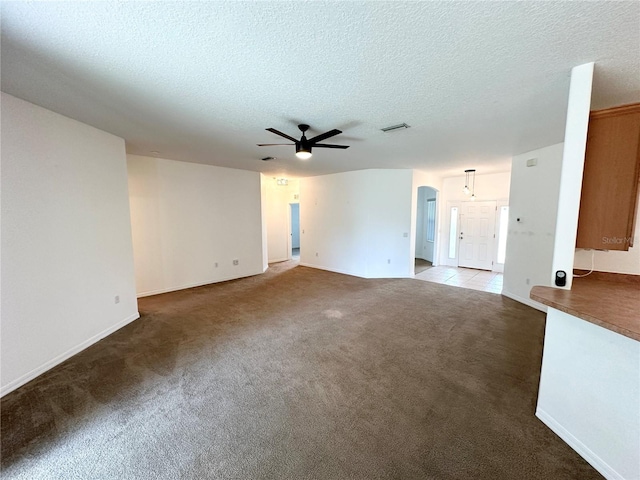 15 Ruth Dr, Palm Coast, FL 32164 - unfurnished living room with a ceiling fan, carpet floors, a textured ceiling, baseboards, and arched walkways