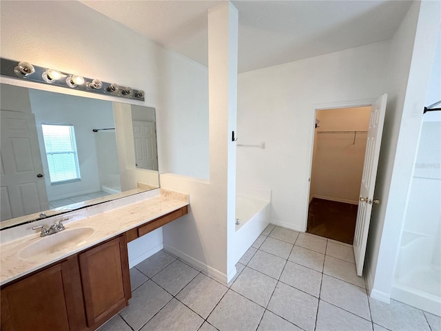 15 Ruth Dr, Palm Coast, FL 32164 - bathroom featuring tile patterned floors, a garden tub, vanity, a walk in closet, and baseboards