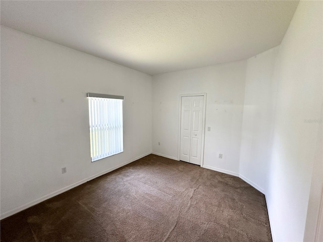 15 Ruth Dr, Palm Coast, FL 32164 - spare room featuring dark colored carpet, baseboards, and a textured ceiling