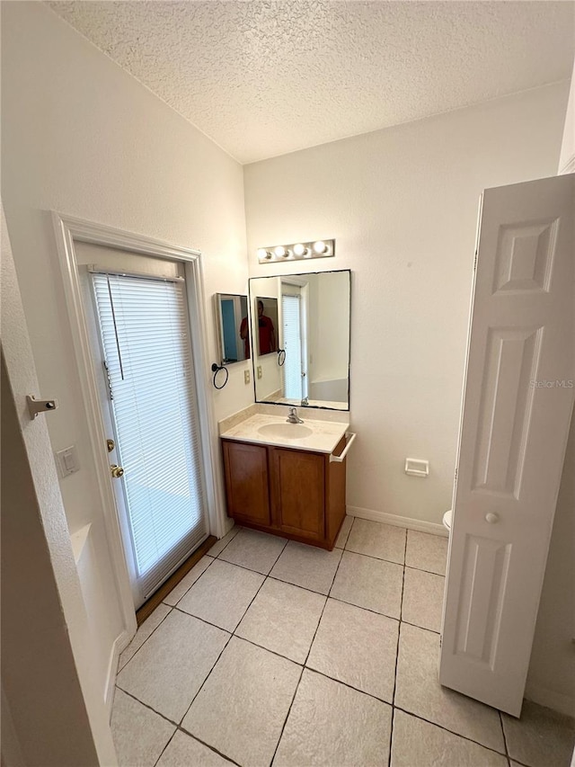 15 Ruth Dr, Palm Coast, FL 32164 - bathroom featuring a textured ceiling, vanity, tile patterned flooring, toilet, and baseboards