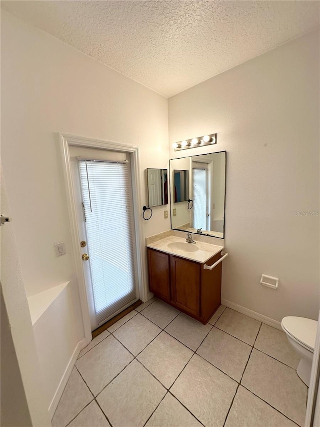 15 Ruth Dr, Palm Coast, FL 32164 - bathroom with a textured ceiling, vanity, tile patterned floors, toilet, and baseboards
