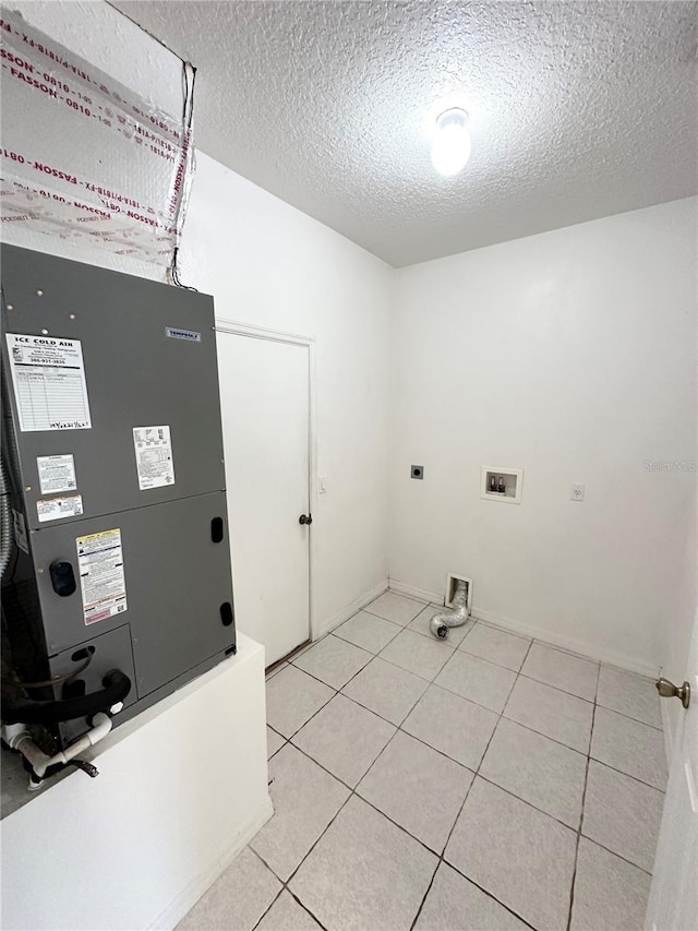 15 Ruth Dr, Palm Coast, FL 32164 - laundry area with electric dryer hookup, a textured ceiling, light tile patterned floors, washer hookup, and baseboards