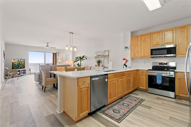 80 Surfview Dr Unit 718, Palm Coast, FL 32137 - kitchen with appliances with stainless steel finishes, a peninsula, light wood-type flooring, light countertops, and a textured ceiling