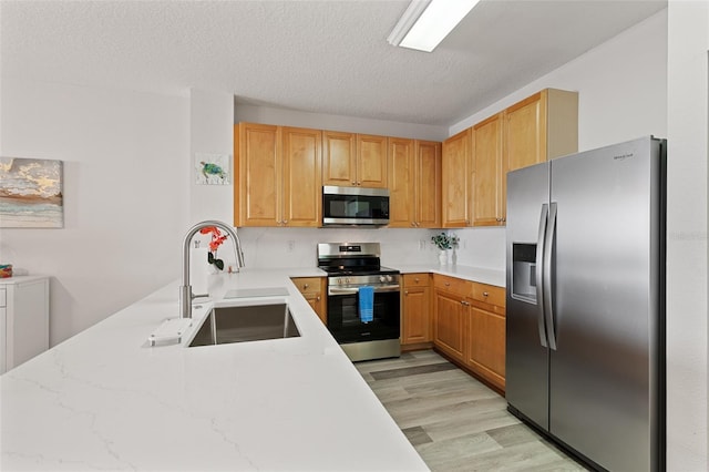 80 Surfview Dr Unit 718, Palm Coast, FL 32137 - kitchen with appliances with stainless steel finishes, light wood-style flooring, a peninsula, a textured ceiling, and light stone countertops