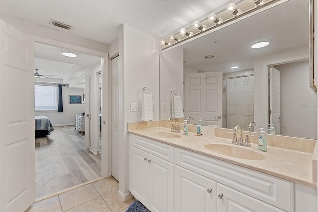 80 Surfview Dr Unit 718, Palm Coast, FL 32137 - ensuite bathroom featuring double vanity, tile patterned flooring, a shower, ceiling fan, and a textured ceiling
