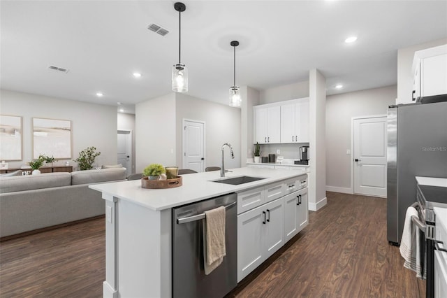 kitchen with stainless steel appliances, a sink, open floor plan, dark wood-style floors, and recessed lighting
