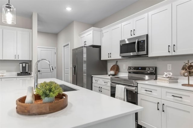 kitchen featuring stainless steel appliances, a sink, white cabinetry, light countertops, and recessed lighting