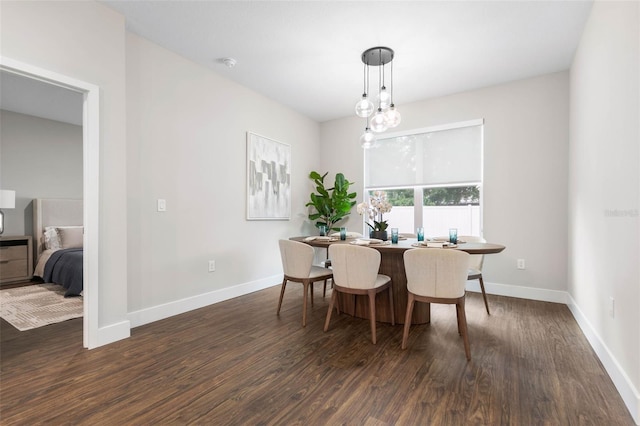 dining space featuring dark wood-style flooring and baseboards