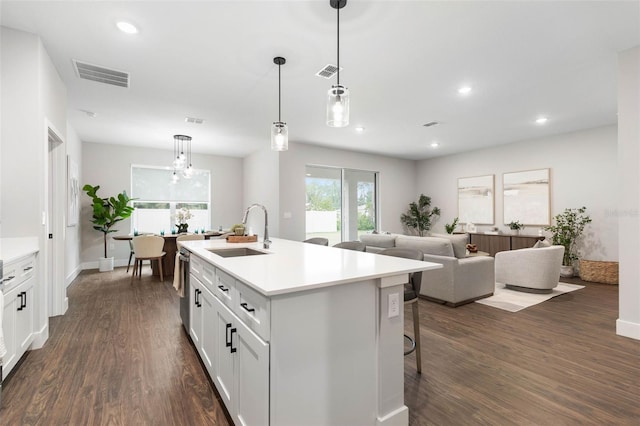 kitchen with a sink, dark wood-style flooring, light countertops, white cabinetry, and recessed lighting
