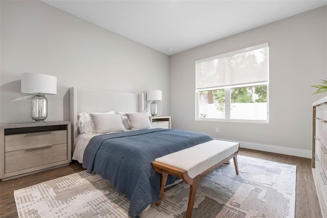 bedroom with dark wood-style flooring and baseboards