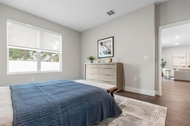 bedroom with wood finished floors, baseboards, and recessed lighting