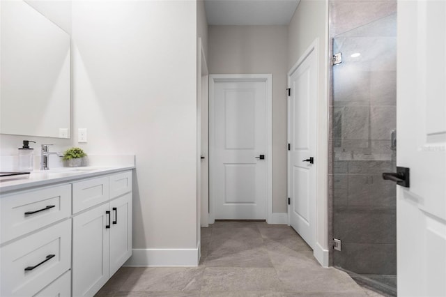 full bath featuring baseboards, a stall shower, and vanity