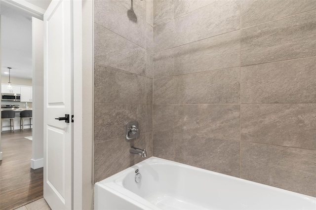 full bath featuring wood finished floors and bathtub / shower combination