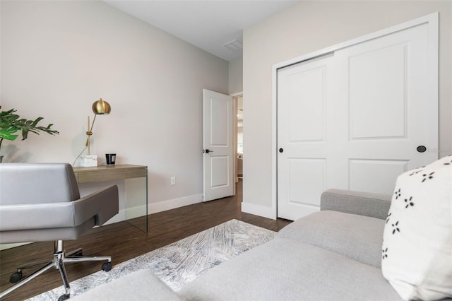 bedroom with wood finished floors, a closet, and baseboards