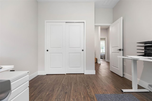 unfurnished office with baseboards and dark wood-type flooring