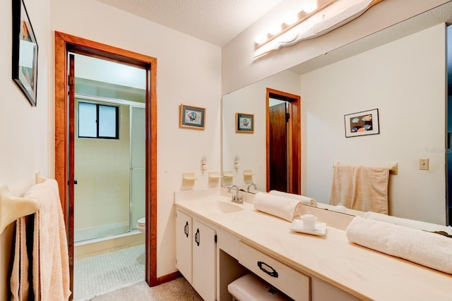 bathroom with a shower stall, vanity, and toilet