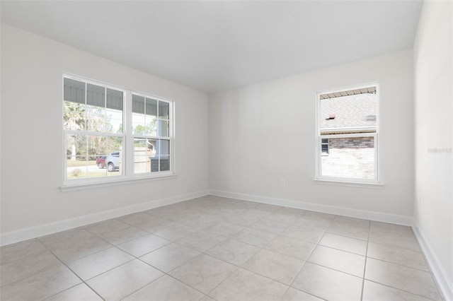 unfurnished room featuring light tile patterned floors and baseboards