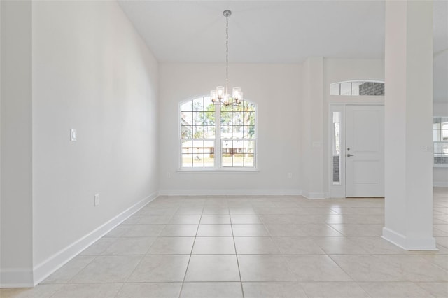 unfurnished dining area with light tile patterned floors, a chandelier, and baseboards