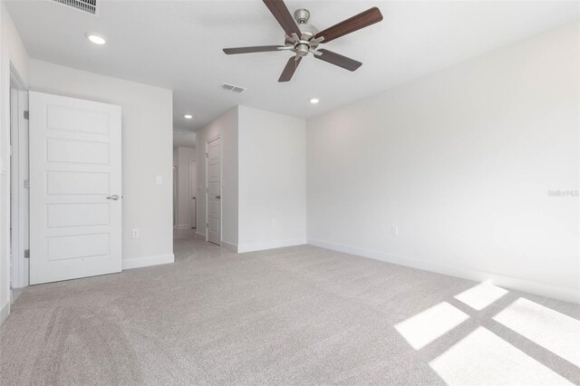 empty room with light carpet, a ceiling fan, recessed lighting, and baseboards