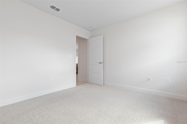 spare room with light carpet and baseboards