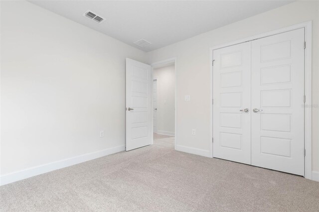 unfurnished bedroom with carpet flooring, baseboards, and a closet