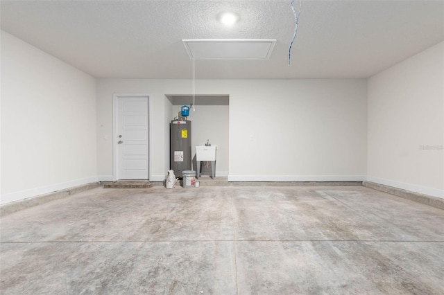 garage featuring water heater, baseboards, and a sink