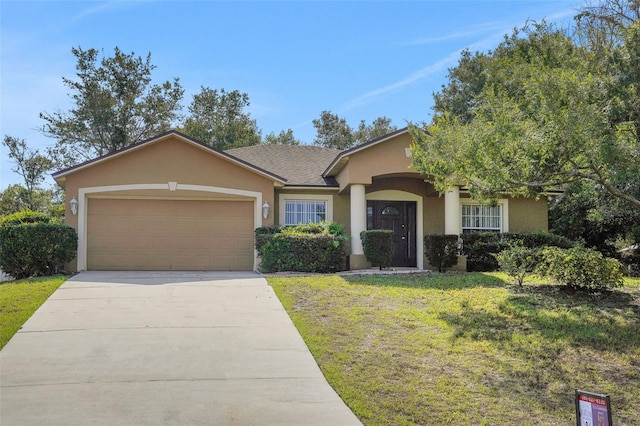 view of front of property featuring stucco siding, an attached garage, a front lawn, and driveway