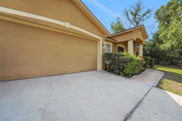 view of side of home featuring stucco siding and concrete driveway