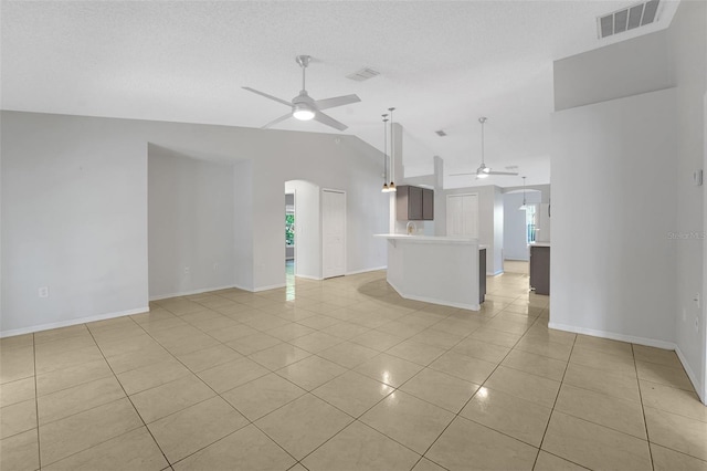 unfurnished living room featuring a ceiling fan, arched walkways, light tile patterned flooring, lofted ceiling, and plenty of natural light