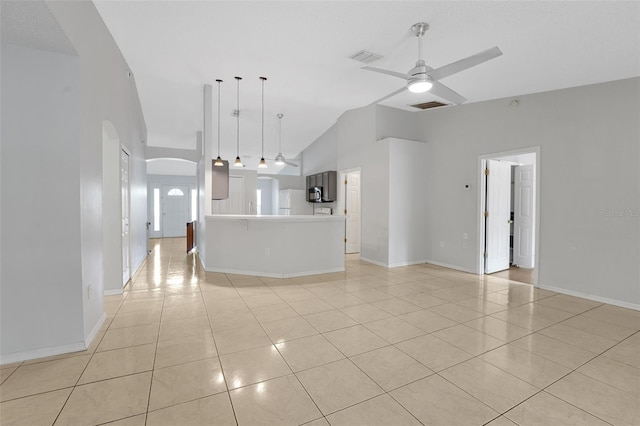 unfurnished living room featuring arched walkways, light tile patterned floors, a ceiling fan, baseboards, and high vaulted ceiling