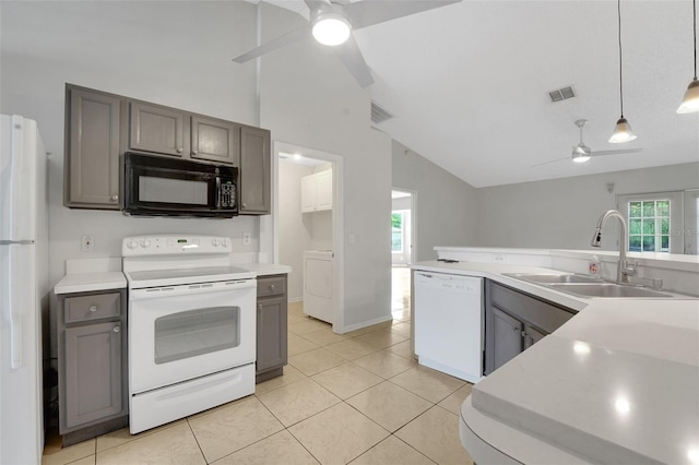 kitchen with white appliances, ceiling fan, a sink, vaulted ceiling, and washer / dryer