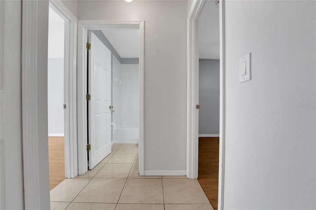 hall with light tile patterned floors and baseboards