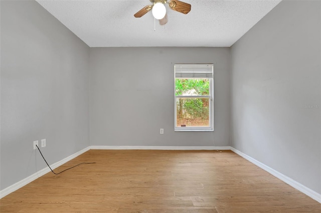 unfurnished room featuring a ceiling fan, light wood-style flooring, a textured ceiling, and baseboards