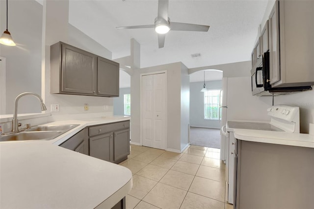 kitchen featuring a sink, white electric range, black microwave, arched walkways, and vaulted ceiling