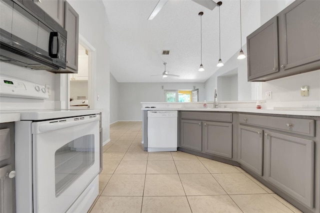 kitchen featuring white appliances, gray cabinets, a sink, a peninsula, and light tile patterned floors