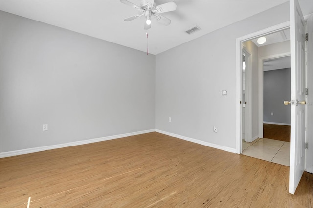 unfurnished room featuring a ceiling fan, light wood-style floors, and baseboards