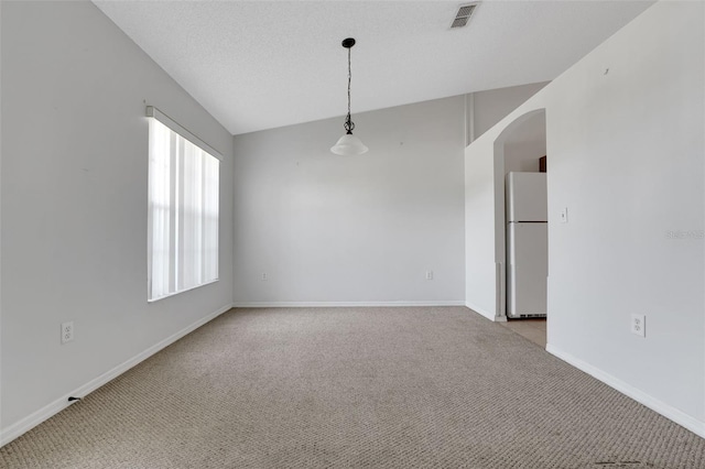 spare room with arched walkways, light carpet, and baseboards