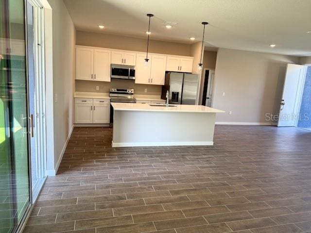 43 Whittingham Ln, Palm Coast, FL 32164 - kitchen featuring appliances with stainless steel finishes, baseboards, recessed lighting, white cabinetry, and an island with sink