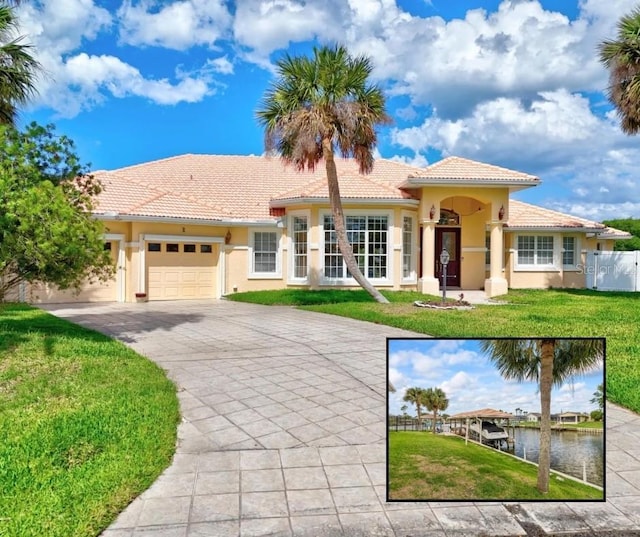 mediterranean / spanish house featuring a garage, driveway, stucco siding, and a tiled roof