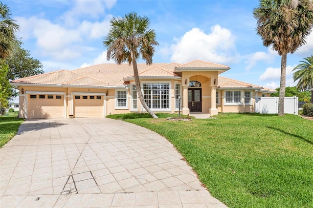 mediterranean / spanish-style home featuring driveway, an attached garage, stucco siding, and a tile roof