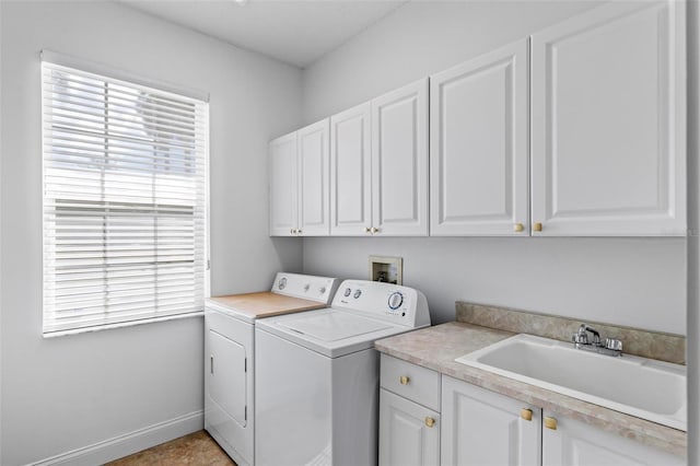 clothes washing area with independent washer and dryer and cabinet space