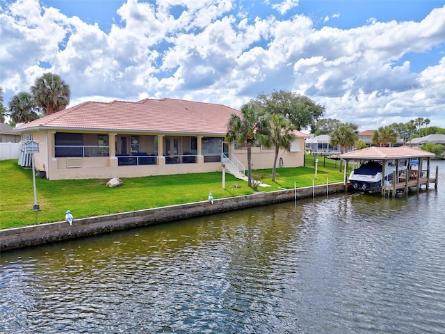 rear view of property featuring a detached carport, a tile roof, a water view, and stucco siding