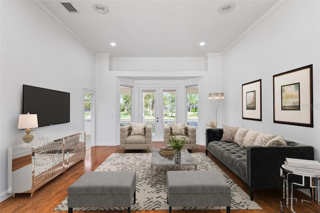 living area with crown molding, wood finished floors, recessed lighting, baseboards, and a high ceiling