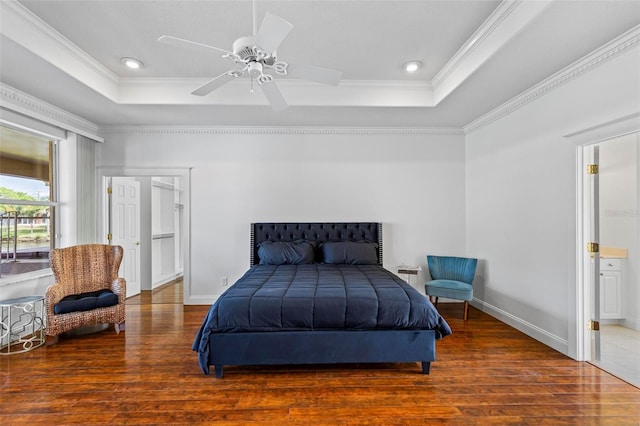bedroom featuring a raised ceiling, wood finished floors, ornamental molding, baseboards, and recessed lighting