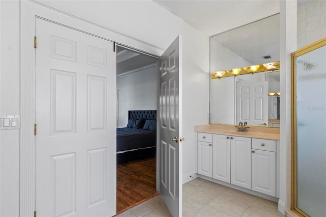 ensuite bathroom featuring tile patterned floors, a shower stall, and vanity