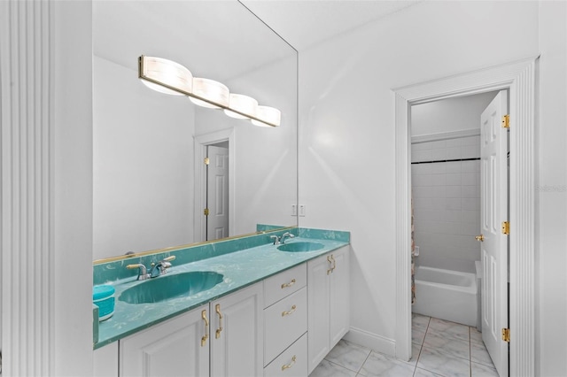 full bathroom with double vanity, marble look tiles, baseboards, and shower / bath combo