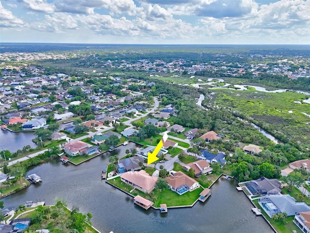 aerial view of property and surrounding area featuring nearby suburban area and a large body of water