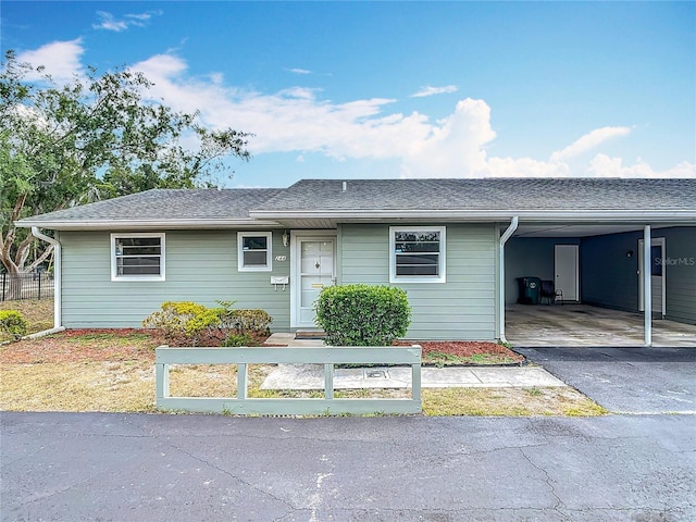 244 Oakleigh Dr Unit 200, Deland, FL 32724 - ranch-style home featuring an attached carport, driveway, fence, and roof with shingles