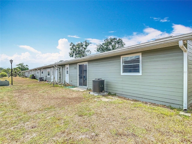 244 Oakleigh Dr Unit 200, Deland, FL 32724 - back of house featuring central AC unit and a lawn